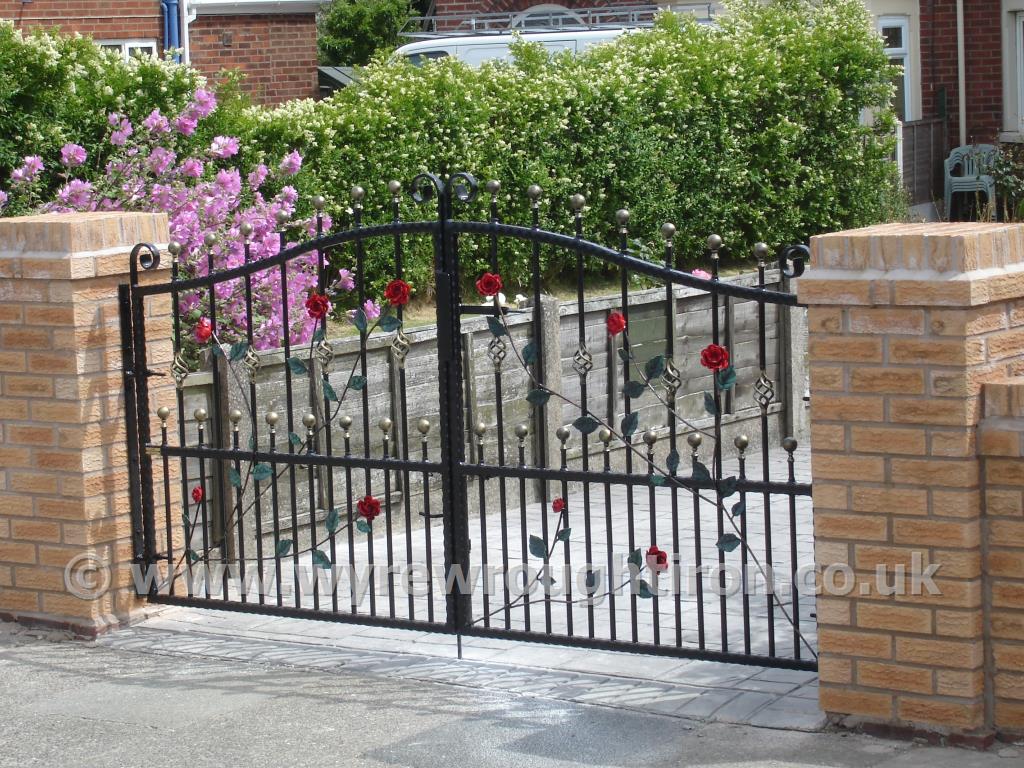 Double arch wrought iron gates with ball railheads, cage twists and hand finished roses, vines and leaf detail. Galvanised and powder coated in black for Fleetwood customer.